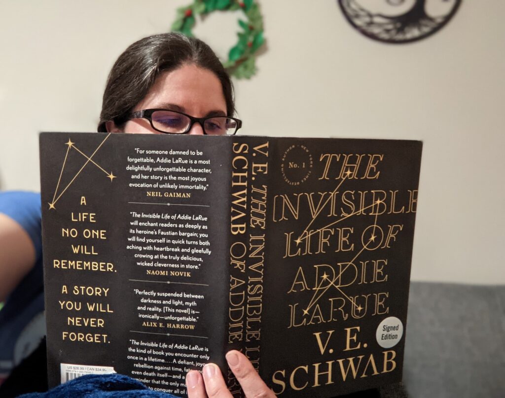 A woman reads The Invisible Life of Addie LaRue by V.E. Schwab