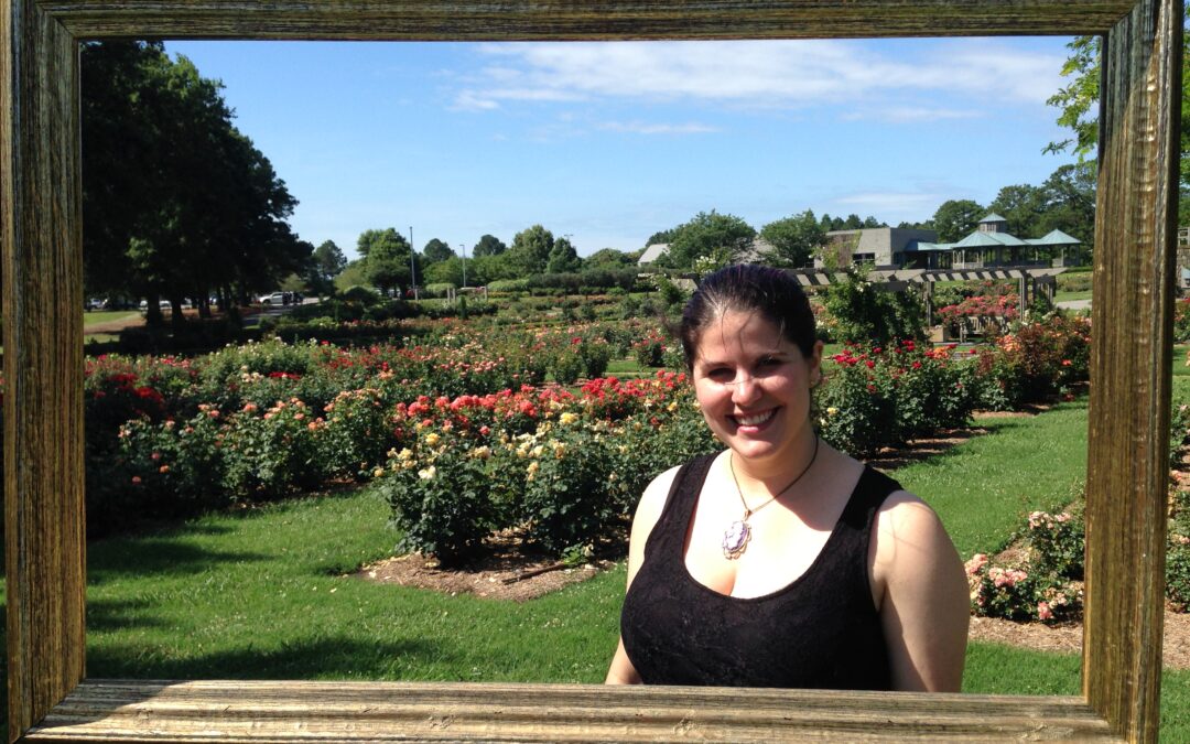 The author posing inside a freestanding frame at a garden