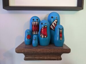 a set of nesting dolls with the faces of cartoon monsters